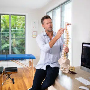 Photograph of Jason Gilbert holding a spine model